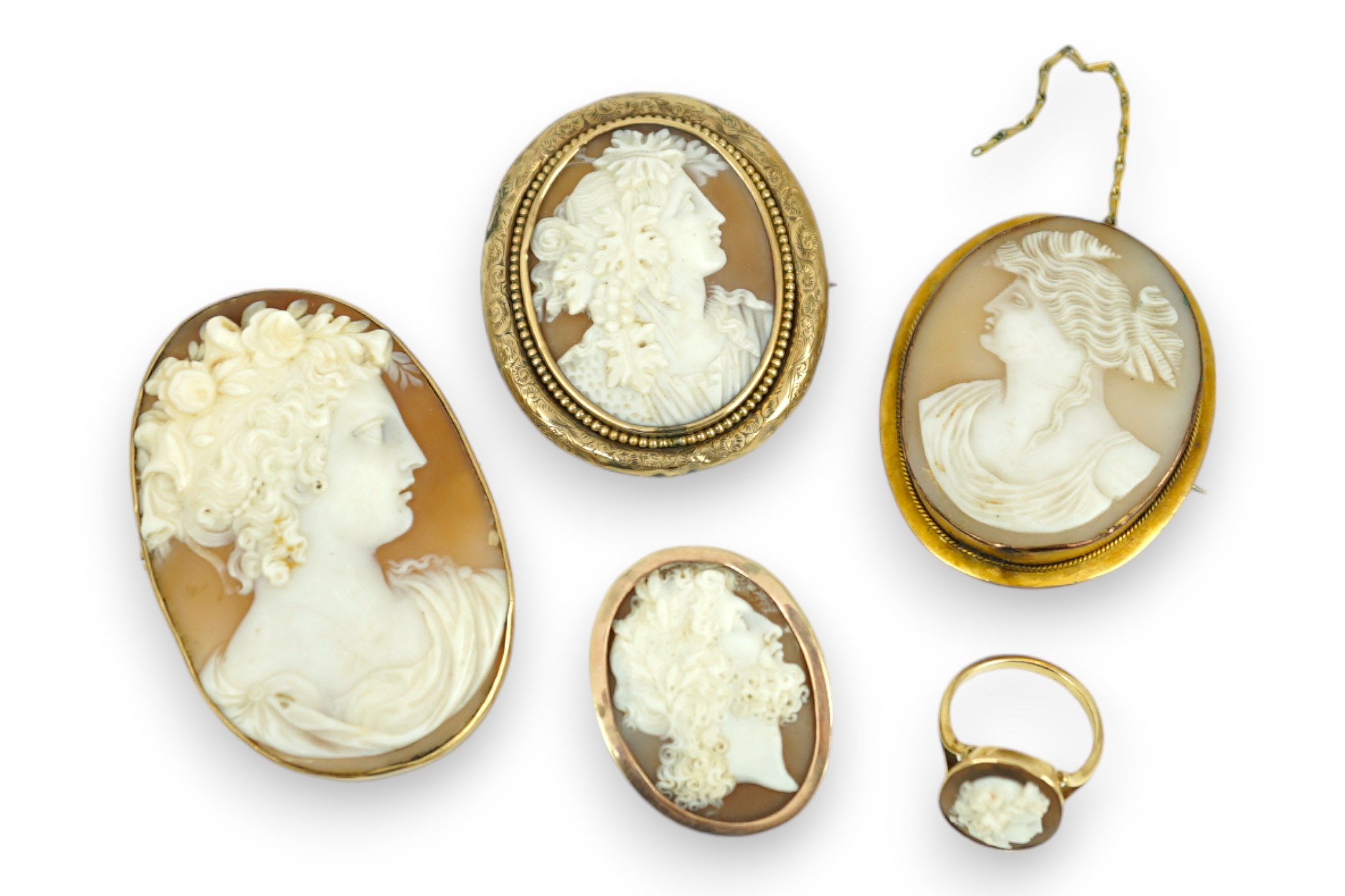 Four assorted early 20th century yellow metal mounted oval cameo shell brooches, largest 60mm, one stamped 9ct and a yellow metal mounted oval cameo shell ring.